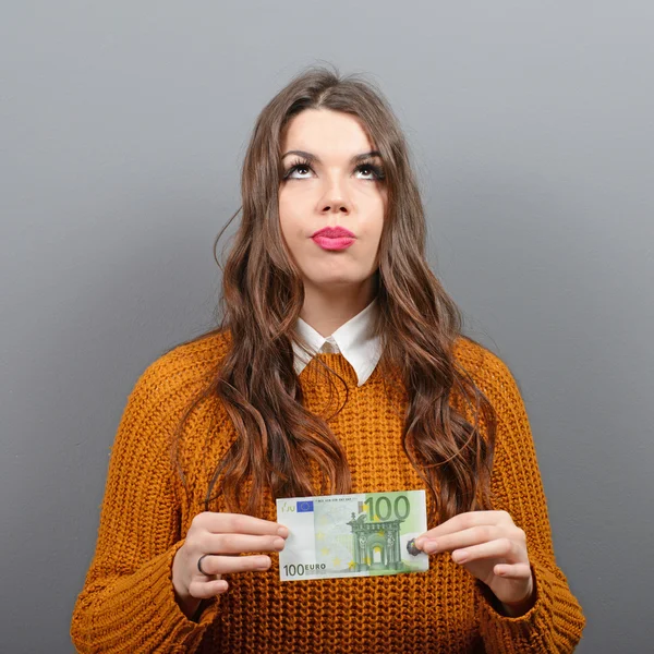 Beautiful woman holding 100 euros banknote against gray backgrou — Stock Photo, Image