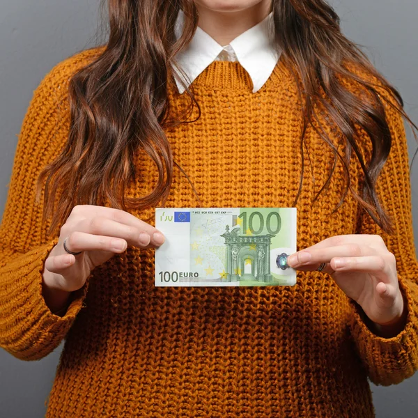 Beautiful woman holding 100 euros banknote against gray backgrou — Stock Photo, Image