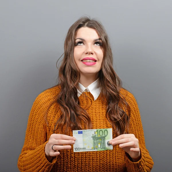 Beautiful woman holding 100 euros banknote against gray backgrou — Stock Photo, Image