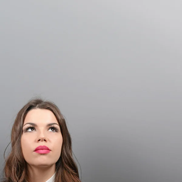 Beautiful woman looking at blank area against  gray background — Stock Photo, Image