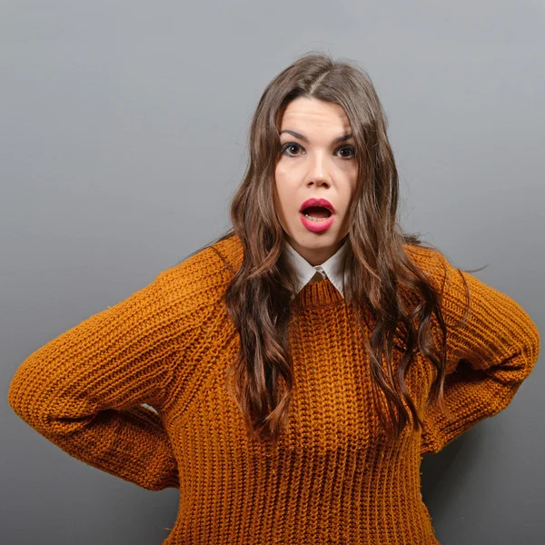 Retrato de uma mulher maravilhada contra fundo cinza — Fotografia de Stock