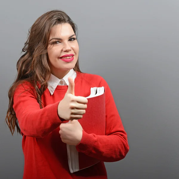 Portrait of happy student woman holding books with thumb up agai — Stock Photo, Image