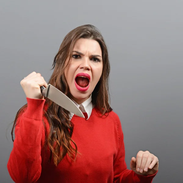 Portrait of killer woman with knife against gray background — Stock Photo, Image