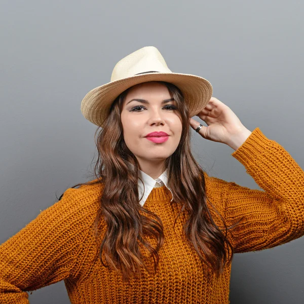 Портрет городской женщины в свитере и шляпе против серого — стоковое фото