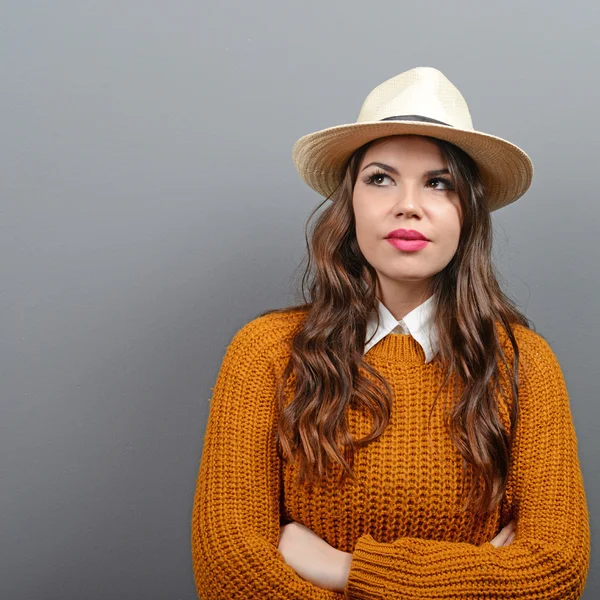 Портрет городской женщины в свитере и шляпе против серого — стоковое фото