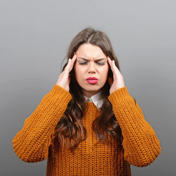 Portrait of woman with headache against gray background — Stock Photo, Image