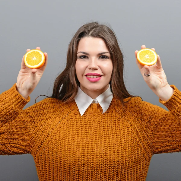 Retrato de mujer joven y saludable con naranjas contra ba gris — Foto de Stock