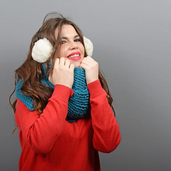 Portrait of young beautiful woman in winter clothes against gray — Stock Photo, Image