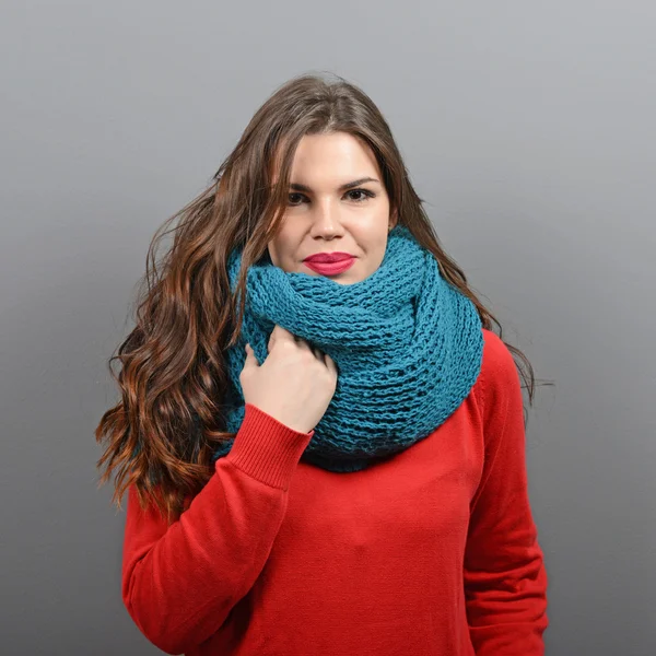 Portrait of young beautiful woman in winter clothes against gray — Stock Photo, Image