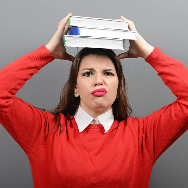 Portrait of woman student tired of learning against gray backgro Royalty Free Stock Photos