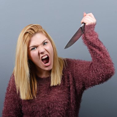 Portrait of killer woman with knife against gray background clipart