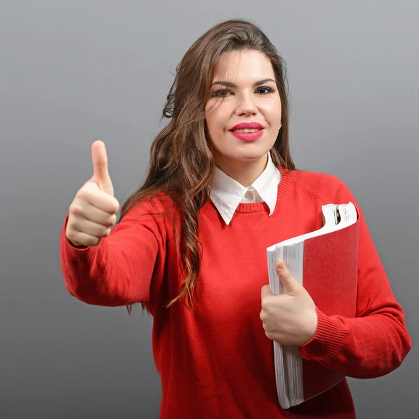 Portrait of happy student woman holding books with thumb up agai — Stock Photo, Image