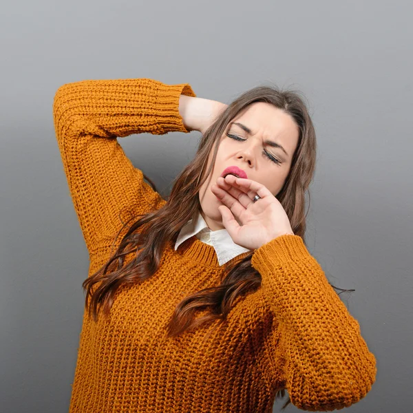 Retrato de mujer joven estirándose y bostezando contra la espalda gris —  Fotos de Stock