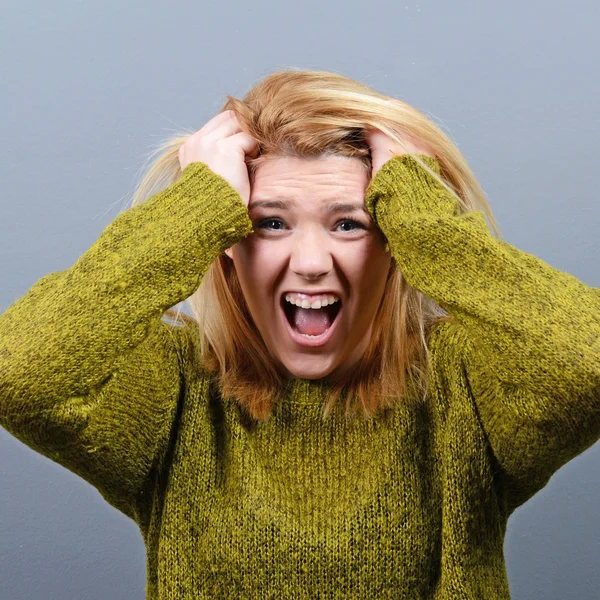 Retrato de uma mulher histérica de arrancar cabelo contra bac cinza — Fotografia de Stock