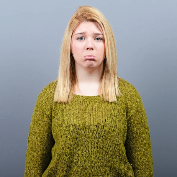 Porträt einer traurigen Frau vor grauem Hintergrund — Stockfoto