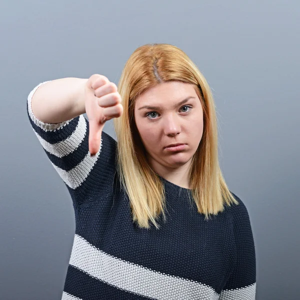Portret kobiety pokazuje kciuk w dół jako dezaprobatę wobec gr — Zdjęcie stockowe