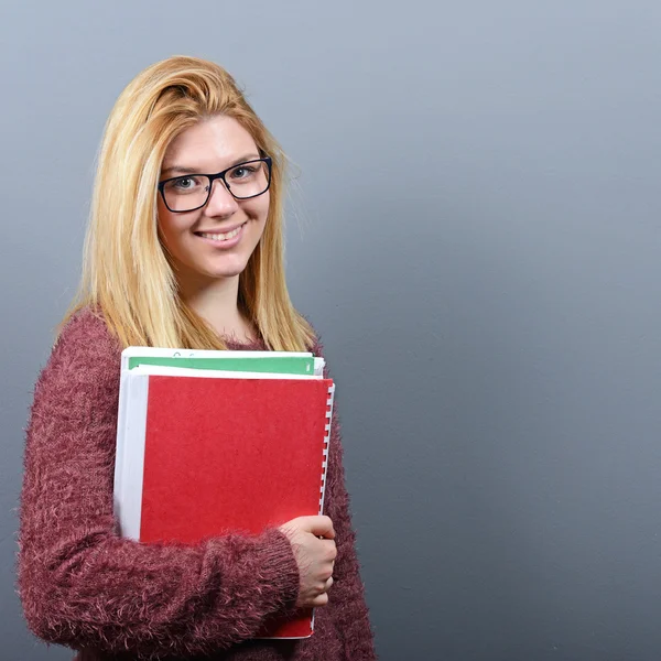 Retrato de una estudiante feliz sosteniendo libros con el pulgar hacia arriba agai — Foto de Stock