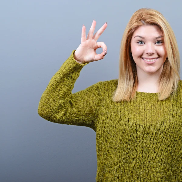 Retrato de mujer feliz mostrando signo de ok contra fondo gris —  Fotos de Stock