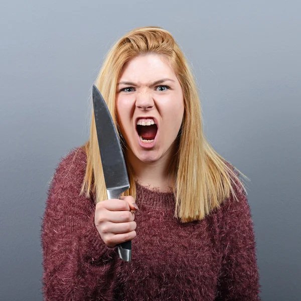 Retrato de mujer asesina con cuchillo sobre fondo gris —  Fotos de Stock