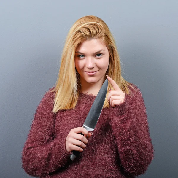 Retrato de mujer asesina con cuchillo sobre fondo gris — Foto de Stock