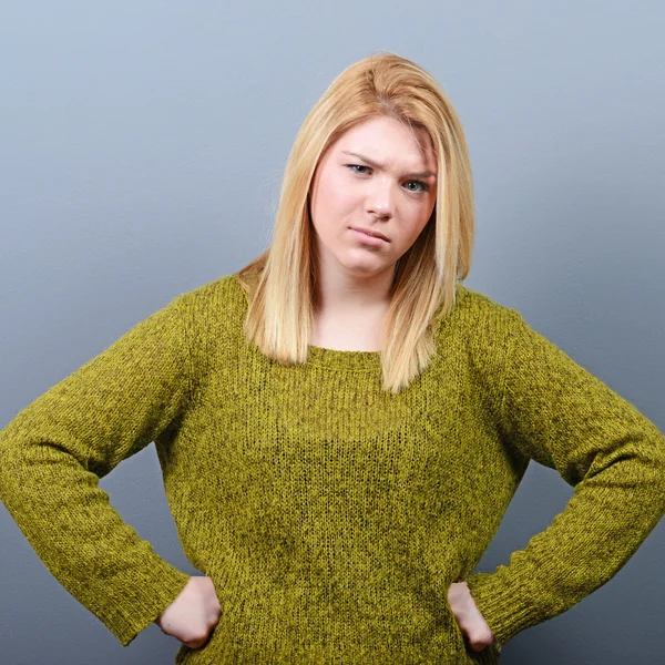 Portrait of mad woman against gray background