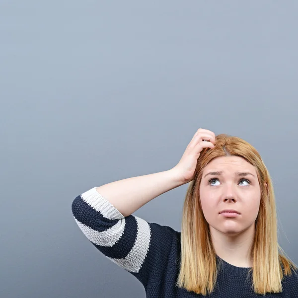 Portret van doordachte vrouw tegen de grijze achtergrond — Stockfoto