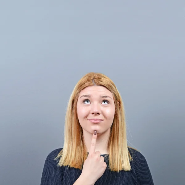 Portret van de vrouw op de proppen met een idee tegen de grijze achtergrond — Stockfoto