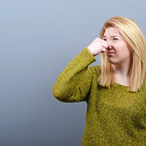 Porträt einer Frau, die die Nase mit der Hand bedeckt und zeigt, dass etwas — Stockfoto