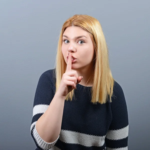 Retrato de mujer sosteniendo el dedo sobre los labios como gesto silencioso aga —  Fotos de Stock