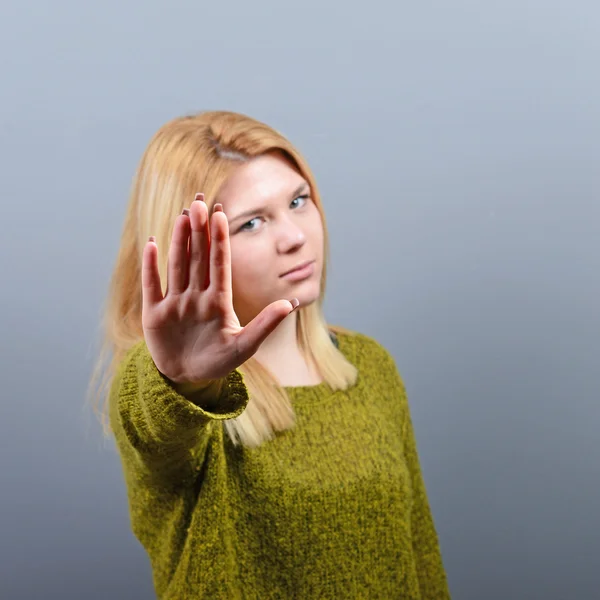 Porträtt av kvinna visar stopp med handen mot grå bakgrund — Stockfoto
