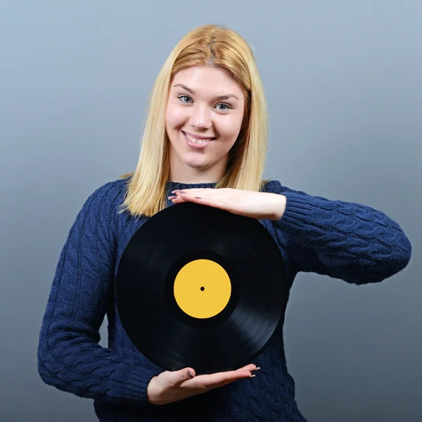 Kvinnan dj porträtt med vinylskiva mot grå bakgrund — Stockfoto