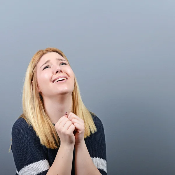 Mujer rezando por algo o suplicando misericordia contra el gris — Foto de Stock