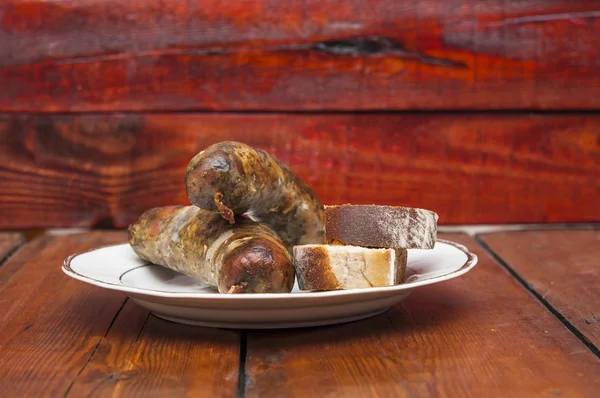 Cerveja e linguiça grelha no fundo de madeira — Fotografia de Stock