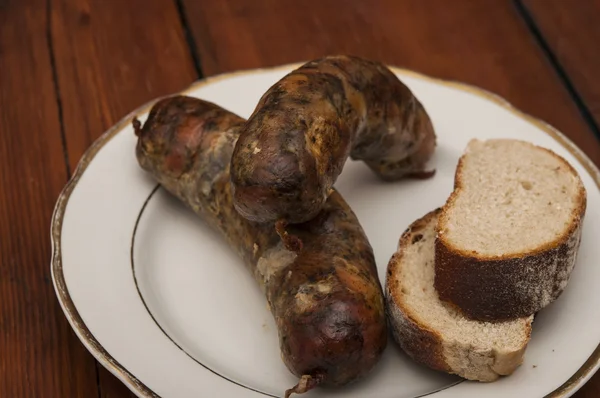 Cerveja e linguiça grelha no fundo de madeira — Fotografia de Stock