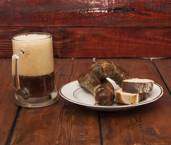 啤酒和烧烤香肠上木制背景 — 图库照片