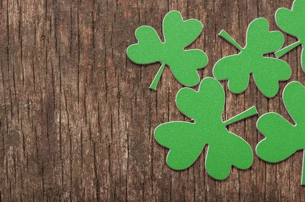 Grüne Kleeblätter oder Shamrocks auf rustikalem Holz Hintergrund — Stockfoto