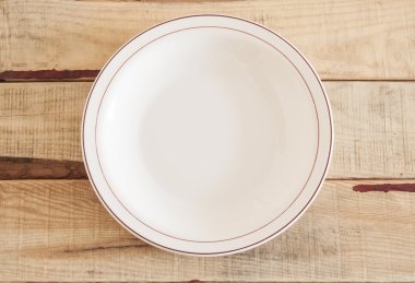 Ahşap zemin üzerinde peçete ile temiz tabak.