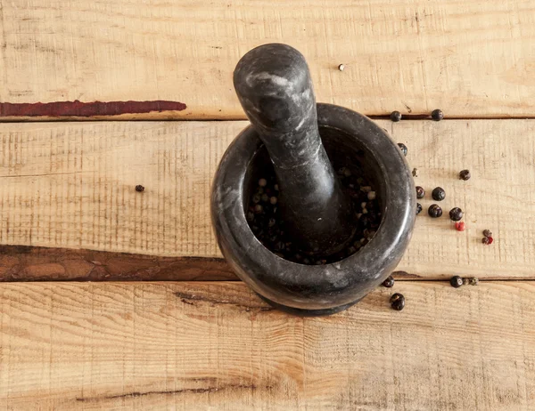 Argamassa e pilão com pimenta e especiarias na mesa de madeira — Fotografia de Stock