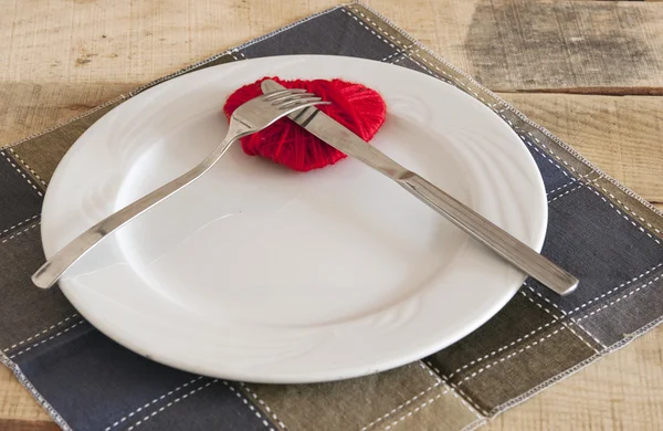 Corazón sobre plato con tenedor y cuchillo —  Fotos de Stock