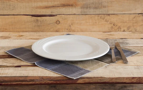 Sauberer Teller mit Serviette auf Holzgrund. — Stockfoto