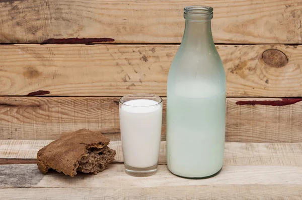 Pane di segale con latte su fondo di legno — Foto Stock