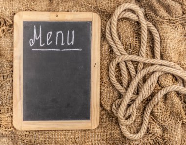 Restoran menüsü. Çok eski bir çuval bezi arkaplan üzerinde duran karatahta menüsünün üst görünümü