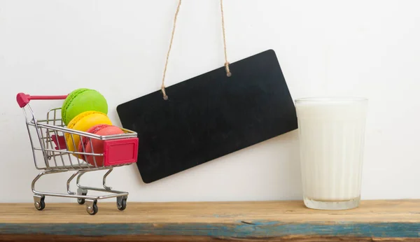 Milchglas Mit Bunten Makronen Auf Holztisch Über Weißer Wand — Stockfoto
