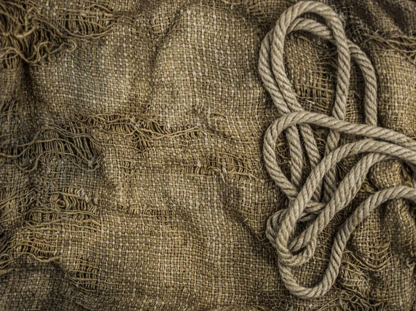 Hemp rope on burlap. Close-up of a natural rope and fabric. Calm nice background.