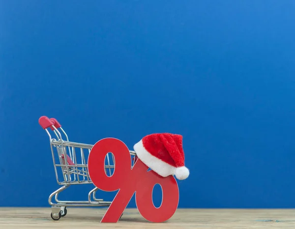 Großer Weihnachtsumsatz Warenkorb Mit Weihnachtsmütze Und Prozentsymbol Auf Holzgrund — Stockfoto