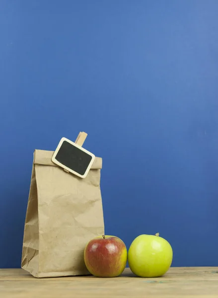 Manzana Con Bolsa Papel Sobre Fondo Madera —  Fotos de Stock