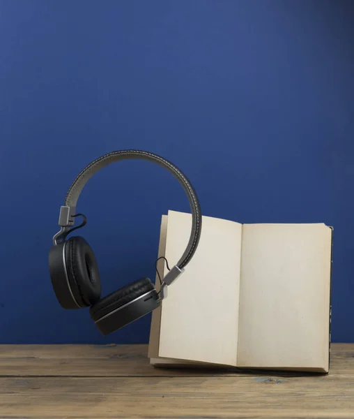 Koptelefoon Met Boek Zweven Lucht Een Donkerblauwe Achtergrond — Stockfoto