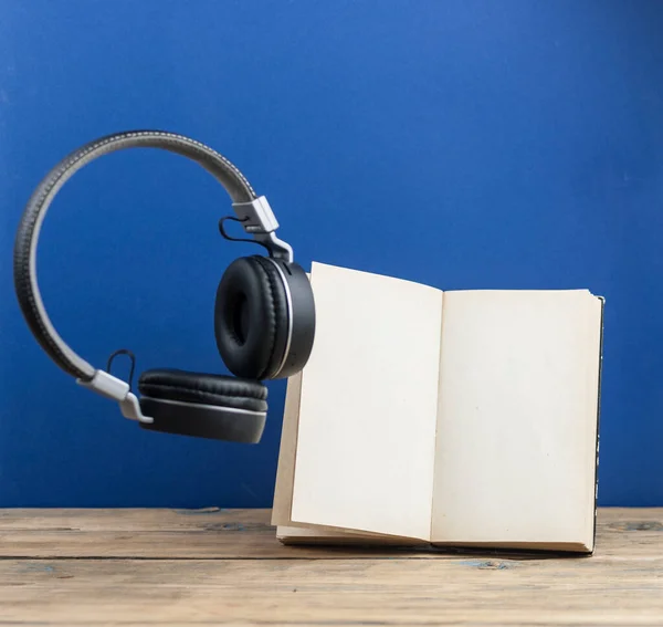 Słuchawki Książki Unoszą Się Powietrzu Ciemnoniebieskim Tle — Zdjęcie stockowe