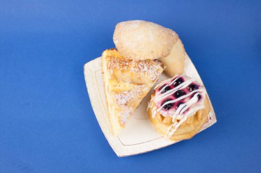 Tatlı pastaları mavi arkaplanda beyaz tabağa yerleştir