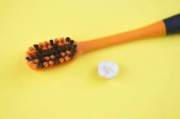 歯ブラシと黄色の背景に落葉ミルクの子供の歯 — ストック写真